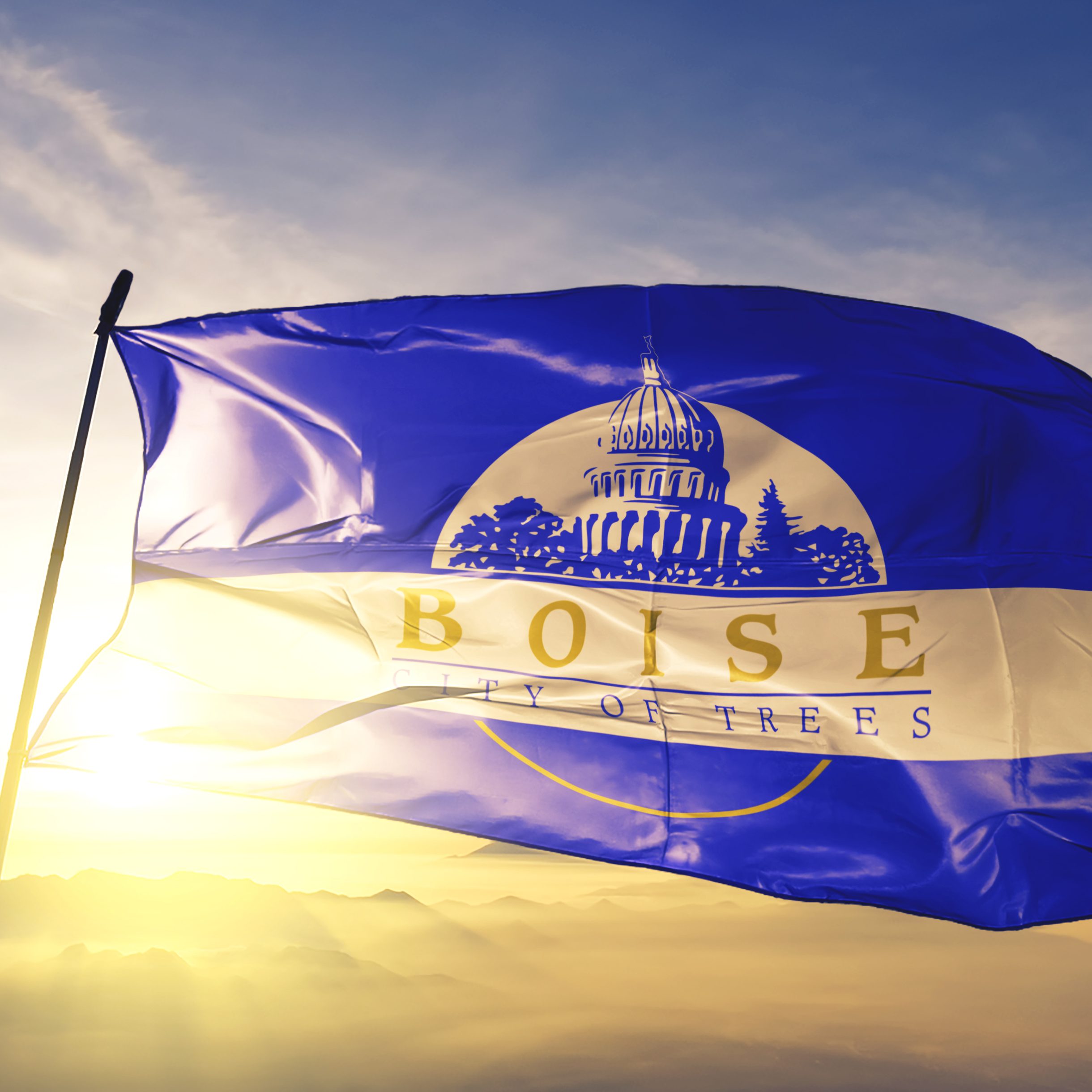 Boise city capital of Idaho of United States flag on flagpole textile cloth fabric waving on the top sunrise mist fog